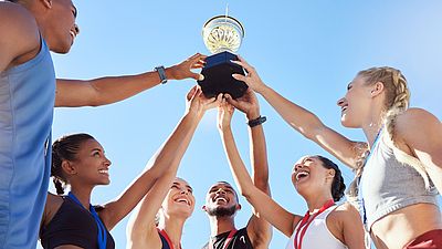 Grupo de jóvenes atletas sosteniendo un trofeo