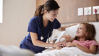 Enfermera con infante y oso de peluche 