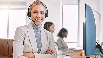 Lächelnde junge Frau bei der Arbeit am Laptop