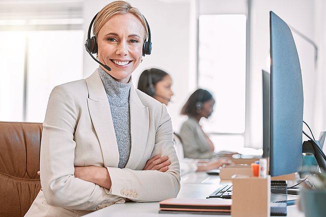 Smiling young woman working on her laptop at work