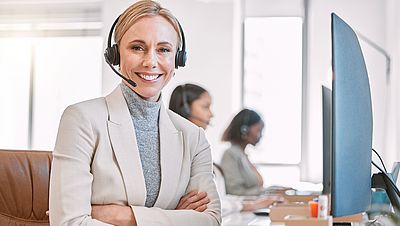 Smiling young woman working on her laptop at work