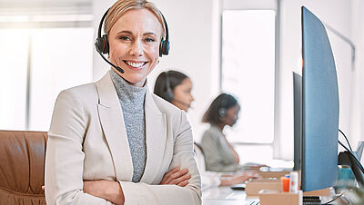 Smiling young woman working on her laptop at work