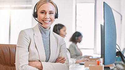 Smiling young woman working on her laptop at work