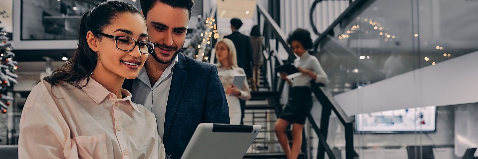 L'homme et la femme au bureau regardent la tablette.