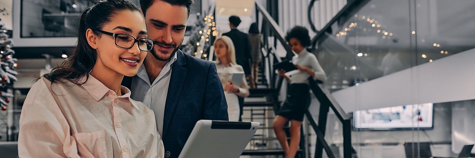 Hombre y mujer en la oficina mirando la tableta.