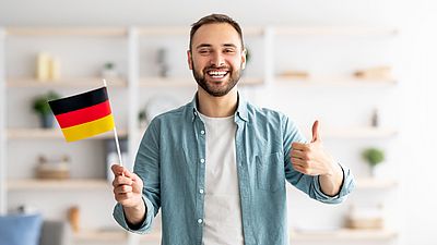 Internationaler lächelnder Mann mit deutscher Flagge