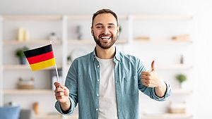 Hombre internacional sonriendo con una bandera alemana