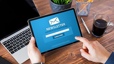 A man subscribing to a newsletter on a tablet