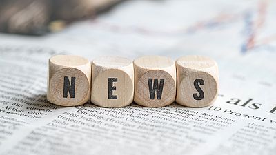 Wooden cubes with letters forming the word "news"