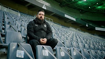 Mann auf einer Tribüne im Stadion