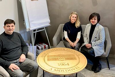 Personen sitzen vor Tisch