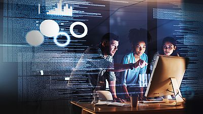 Three people look at a screen