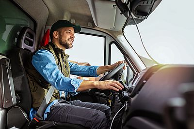 Azubi sitzt im LKW am Steuer