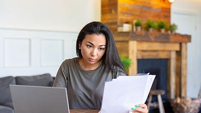 A woman working on her university degree evaluation documents