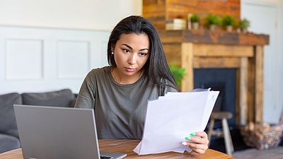 Ein Frau bearbeitet ihre Unterlagen zur Bewertung ihres Hochschulabschlusses