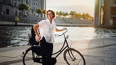 Smiling woman with bicycle in Berlin