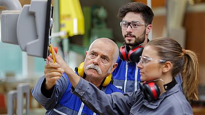 Internationale Gruppe von Menschen arbeiten in einer Werkstatt