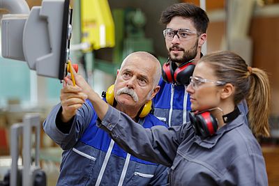Internationale Gruppe von Menschen arbeiten in einer Werkstatt