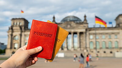 Dos pasaportes frente al edificio del Reichstag en Berlín