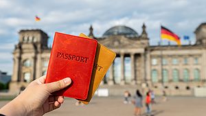 Two passports in front of the Reichstag building in Berlin