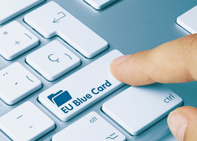 El dedo índice pulsa el botón del teclado "Tarjeta azul UE"