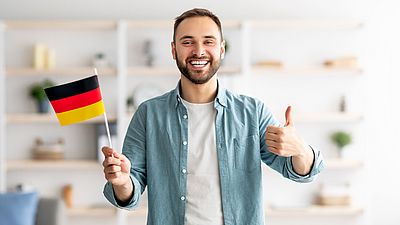 Hombre internacional sonriendo con una bandera alemana