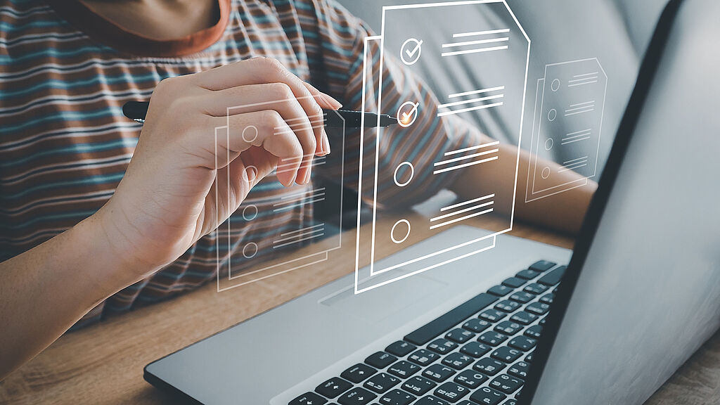 Person checks off a virtual checklist floating above a laptop.