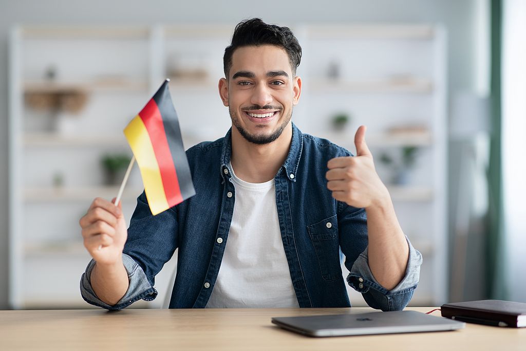 Internationaler lächelnder Mann mit deutscher Flagge