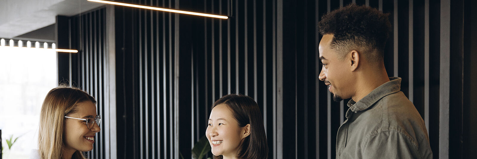 Drei internationale Fachkräfte beim Kaffeetrinken