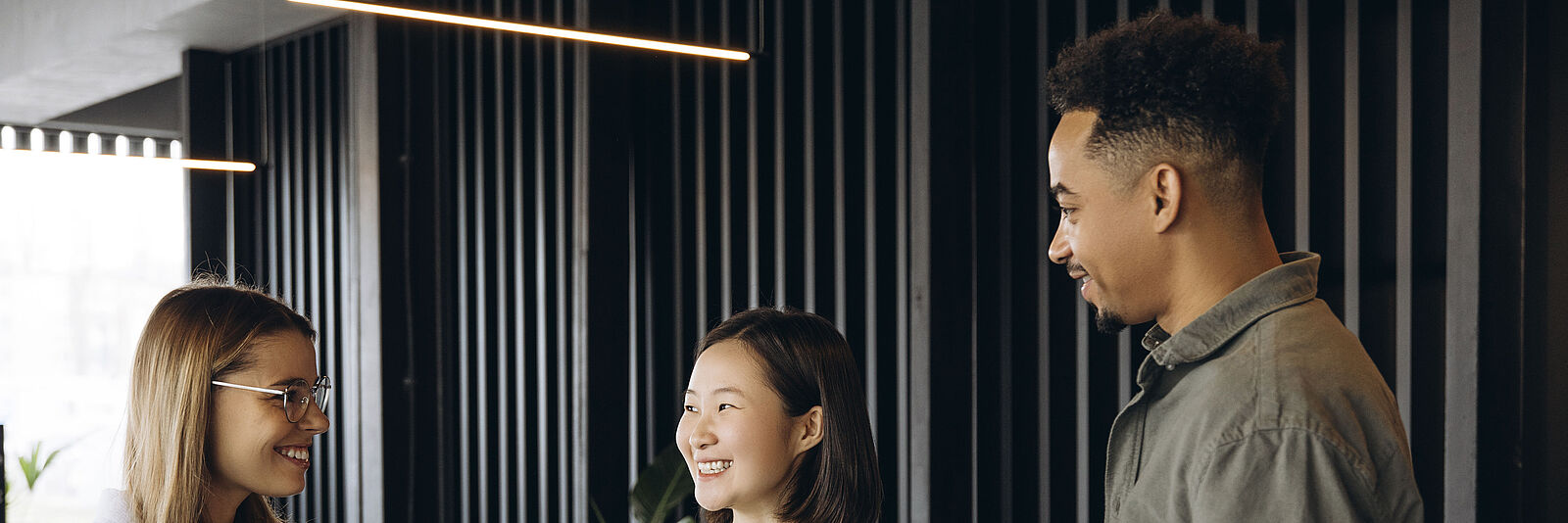 Drei internationale Fachkräfte beim Kaffeetrinken