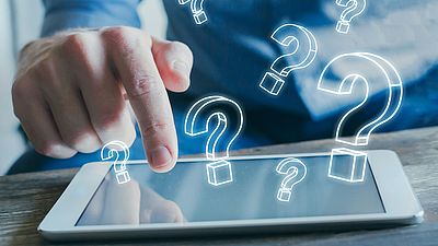 Hand einer Person, die auf einem Tablet nach Visainformationen sucht