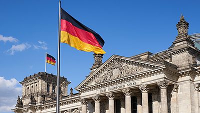 Deutsche Flagge vor dem Deutschen Bundestag in Berlin