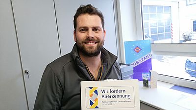 Mann im Büro mit Zertifikat