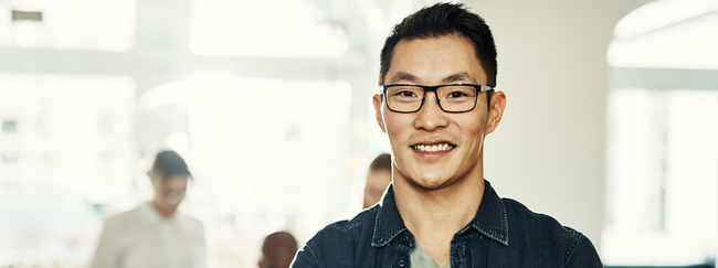 Asiatisch aussehender Mann mit Brille lächelt