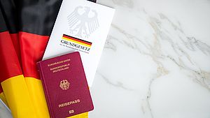 Deutsches Grundgesetz, ein deutscher Pass und eine deutsche Flagge