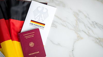 Deutsches Grundgesetz, ein deutscher Pass und eine deutsche Flagge