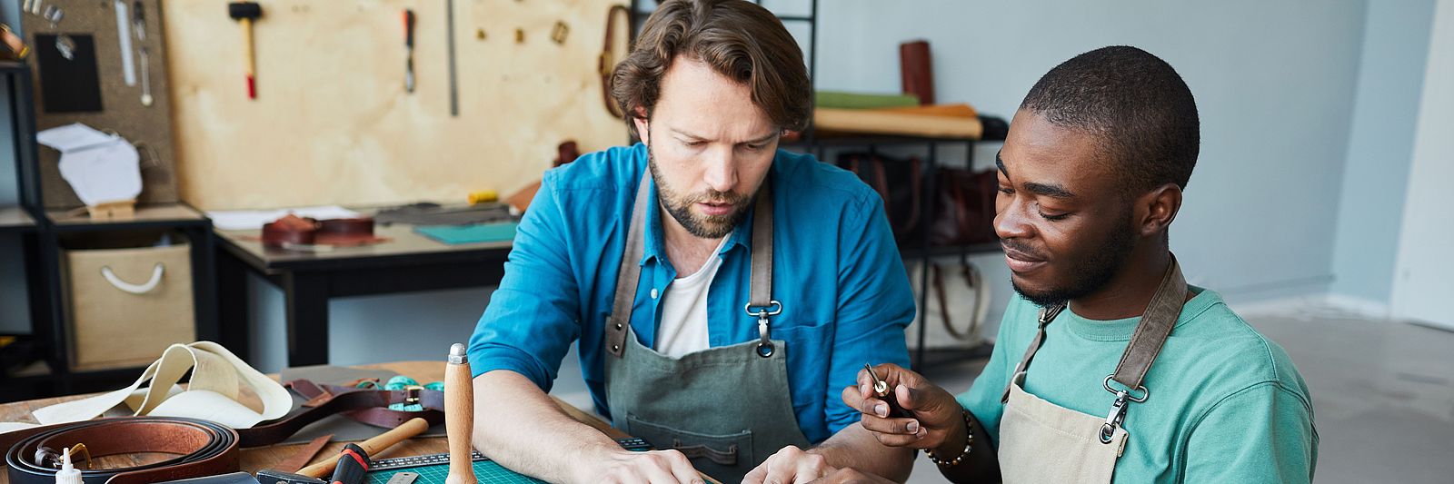 Zwei internationale Männer arbeiten in einem Handwerksbetrieb