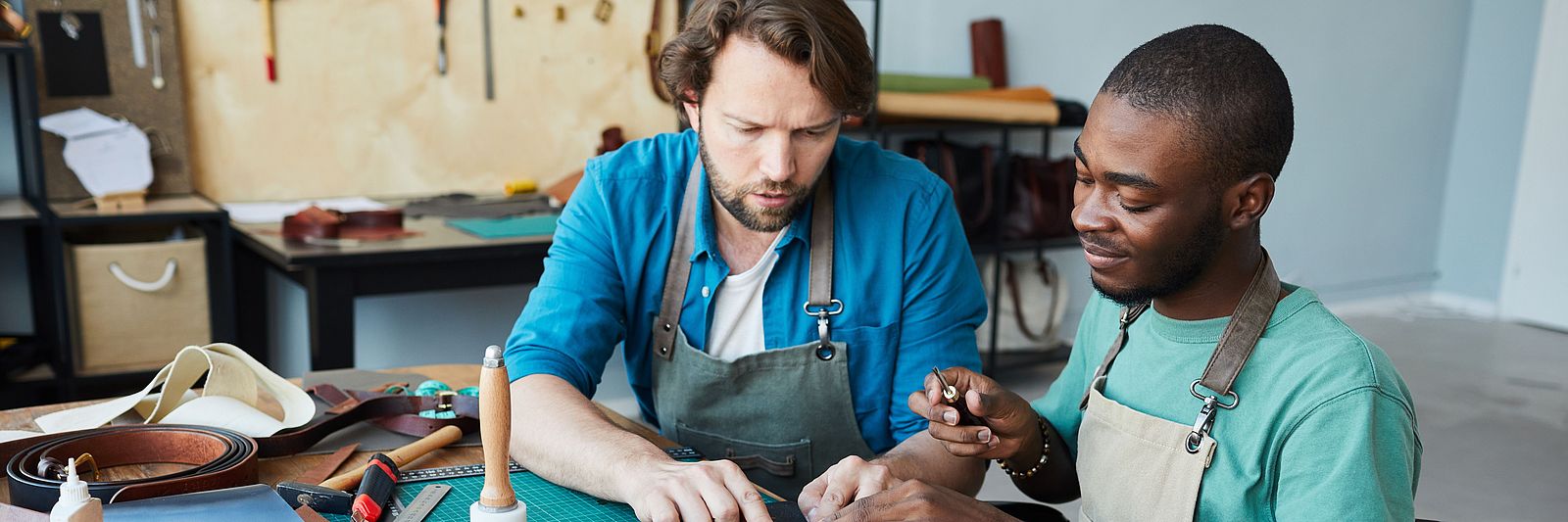 Zwei internationale Männer arbeiten in einem Handwerksbetrieb
