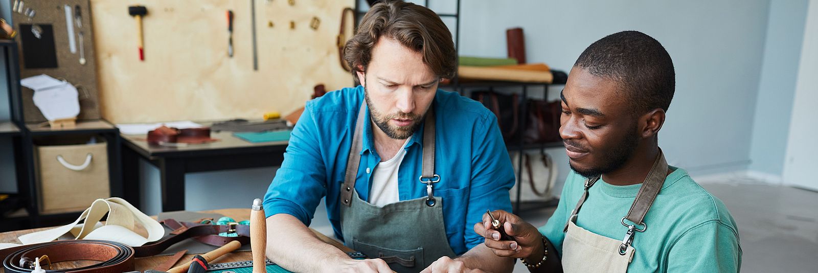 Zwei internationale Männer arbeiten in einem Handwerksbetrieb