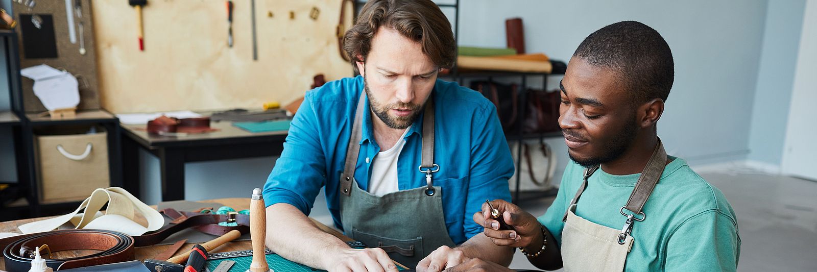 Zwei internationale Männer arbeiten in einem Handwerksbetrieb