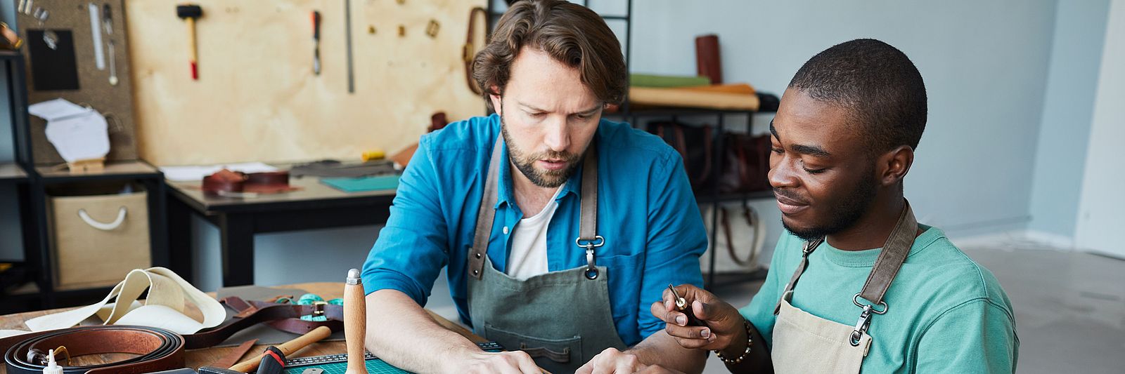 Zwei internationale Männer arbeiten in einem Handwerksbetrieb