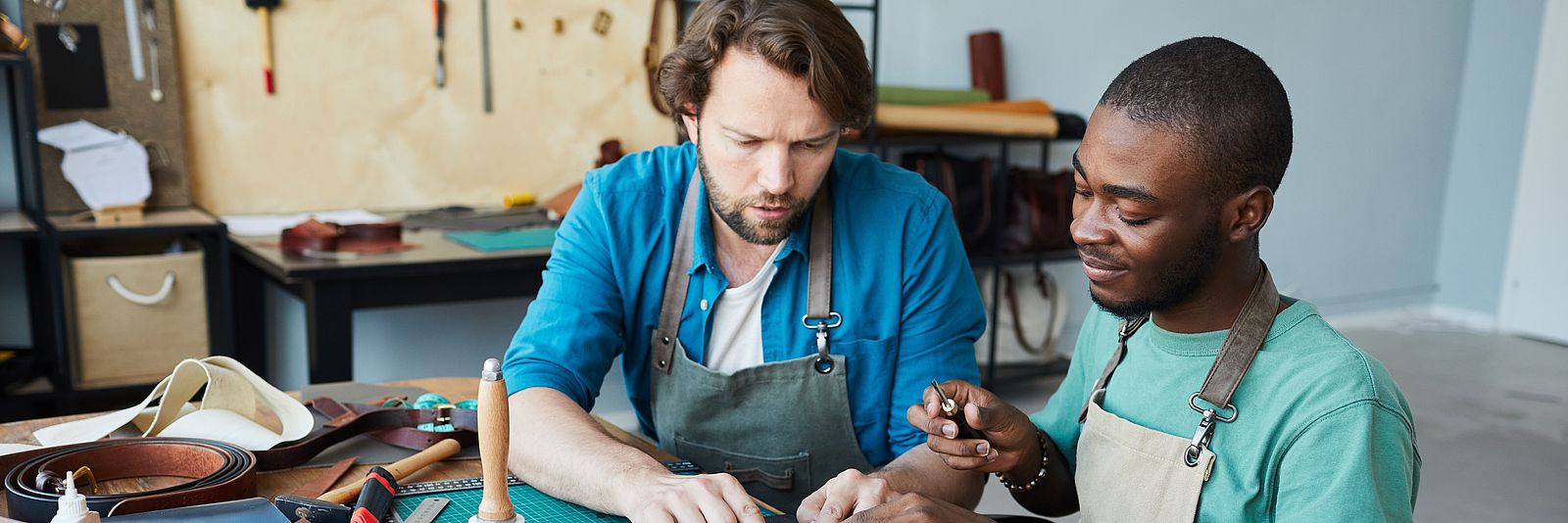 Zwei internationale Männer arbeiten in einem Handwerksbetrieb