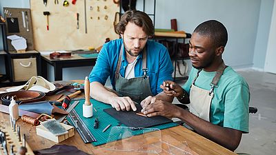 Dos hombres internacionales trabajando en una taller artesanal