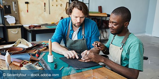 Zwei internationale Männer arbeiten in einem Handwerksbetrieb